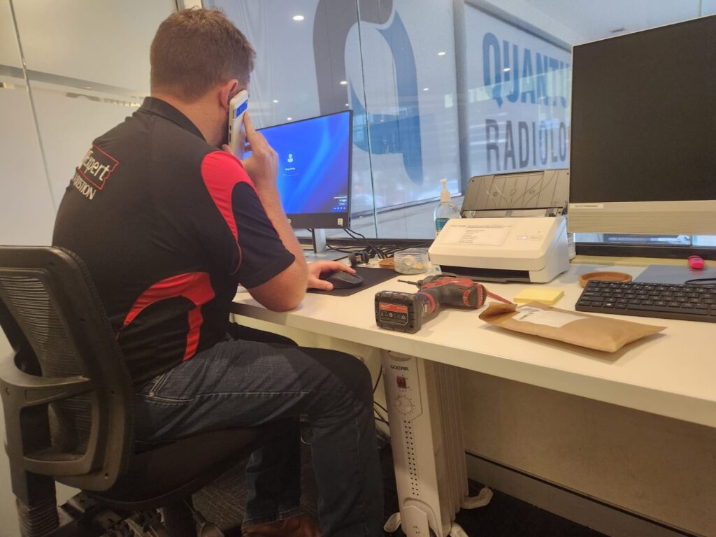 Trucell IT expert is calling someone while working on the HP All-in-one computer
